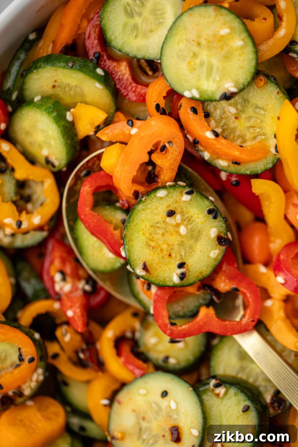 Fresh Cucumber & Bell Pepper Salad 8 A spoon serving up a portion of cucumber and bell pepper salad.