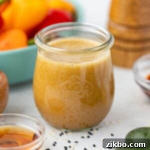 Sesame Ginger Dressing 10 A small jar filled with homemade ginger sesame dressing, showcasing its vibrant color and fresh ingredients.