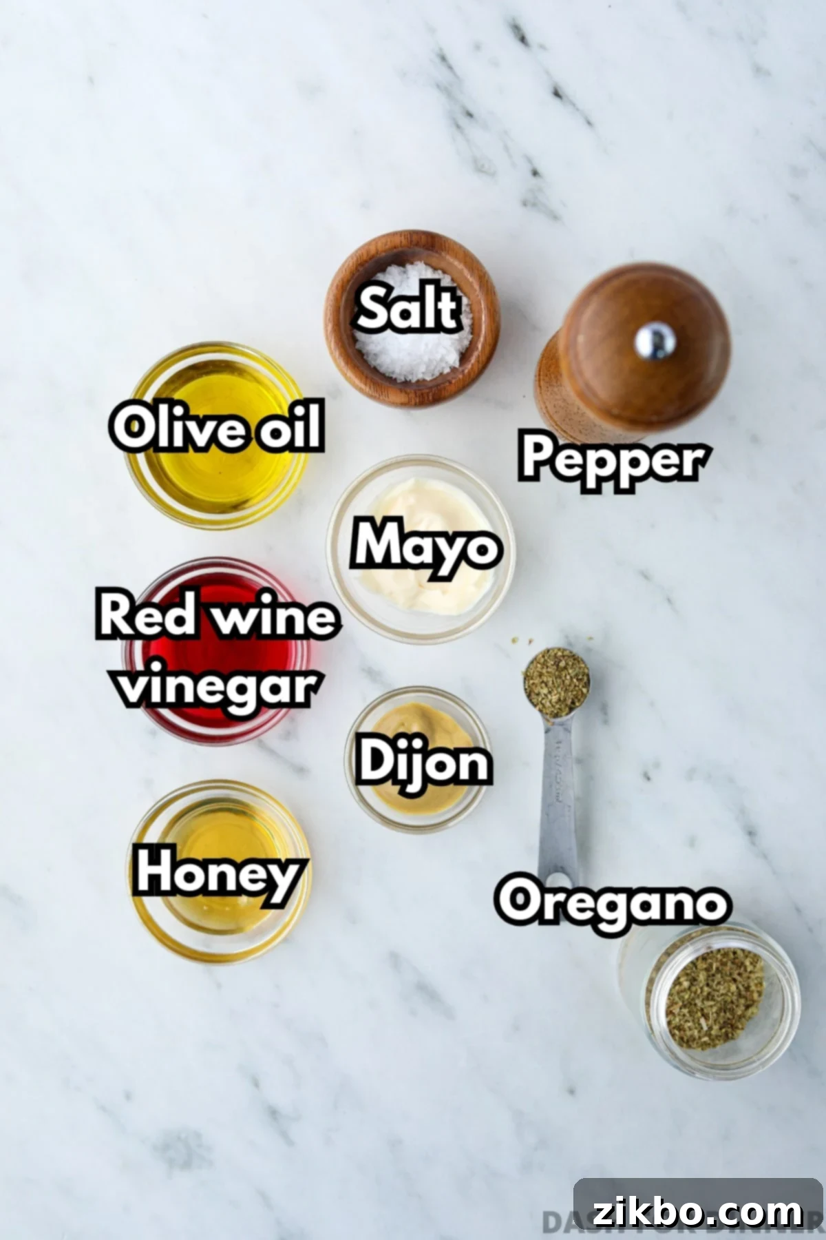 Small bowls displaying fresh, individual ingredients including golden honey, rich olive oil, vibrant red wine vinegar, creamy mayonnaise, and zesty Dijon mustard, prepped for mixing.