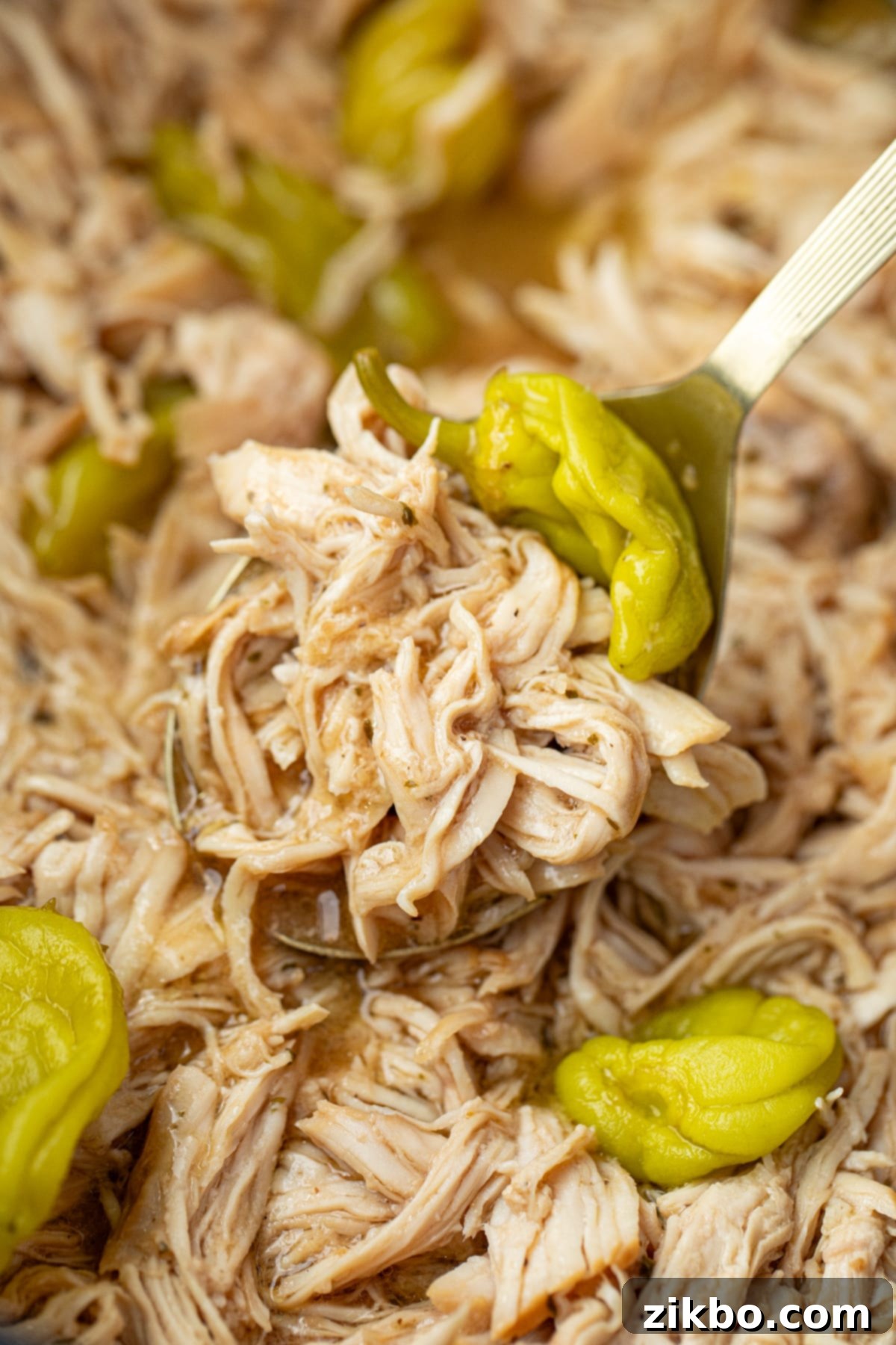 Scooping shredded chicken from a large slow cooker.