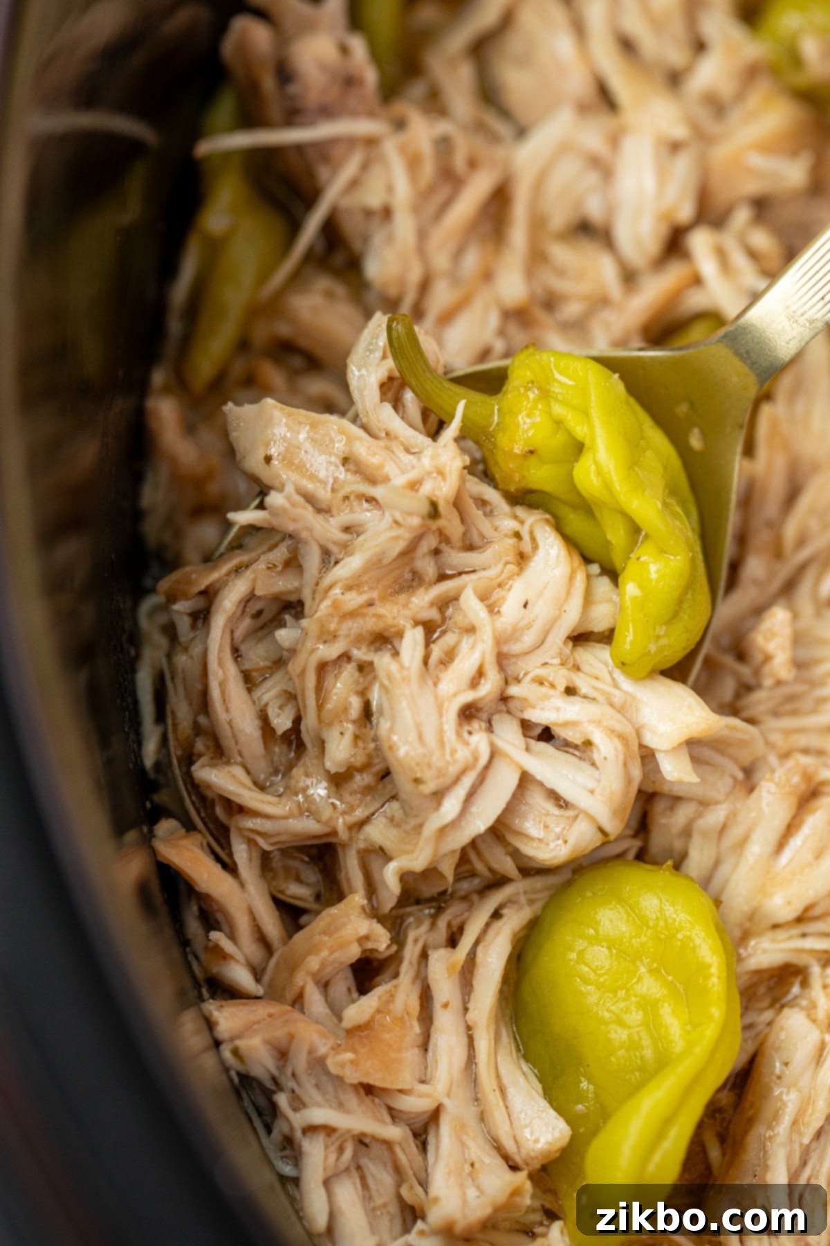 Scooping shredded chicken from a slow cooker.