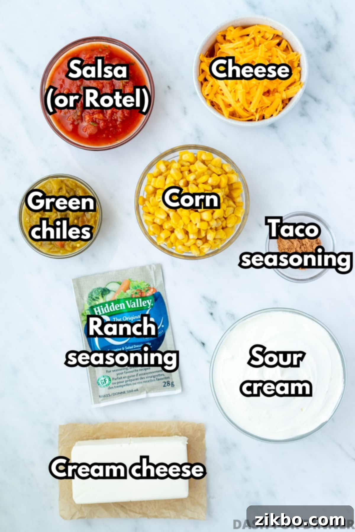 The essential ingredients laid out for making boat dip, including softened cream cheese, sour cream, shredded cheddar cheese, ranch seasoning, and green chilies.