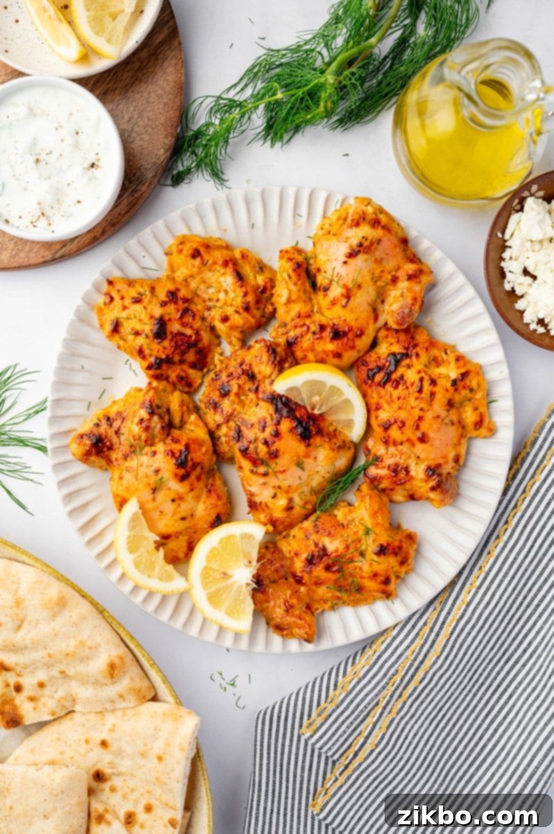 Delicious Greek Yogurt Chicken 8 A plate filled with cooked and seasoned chicken thighs.