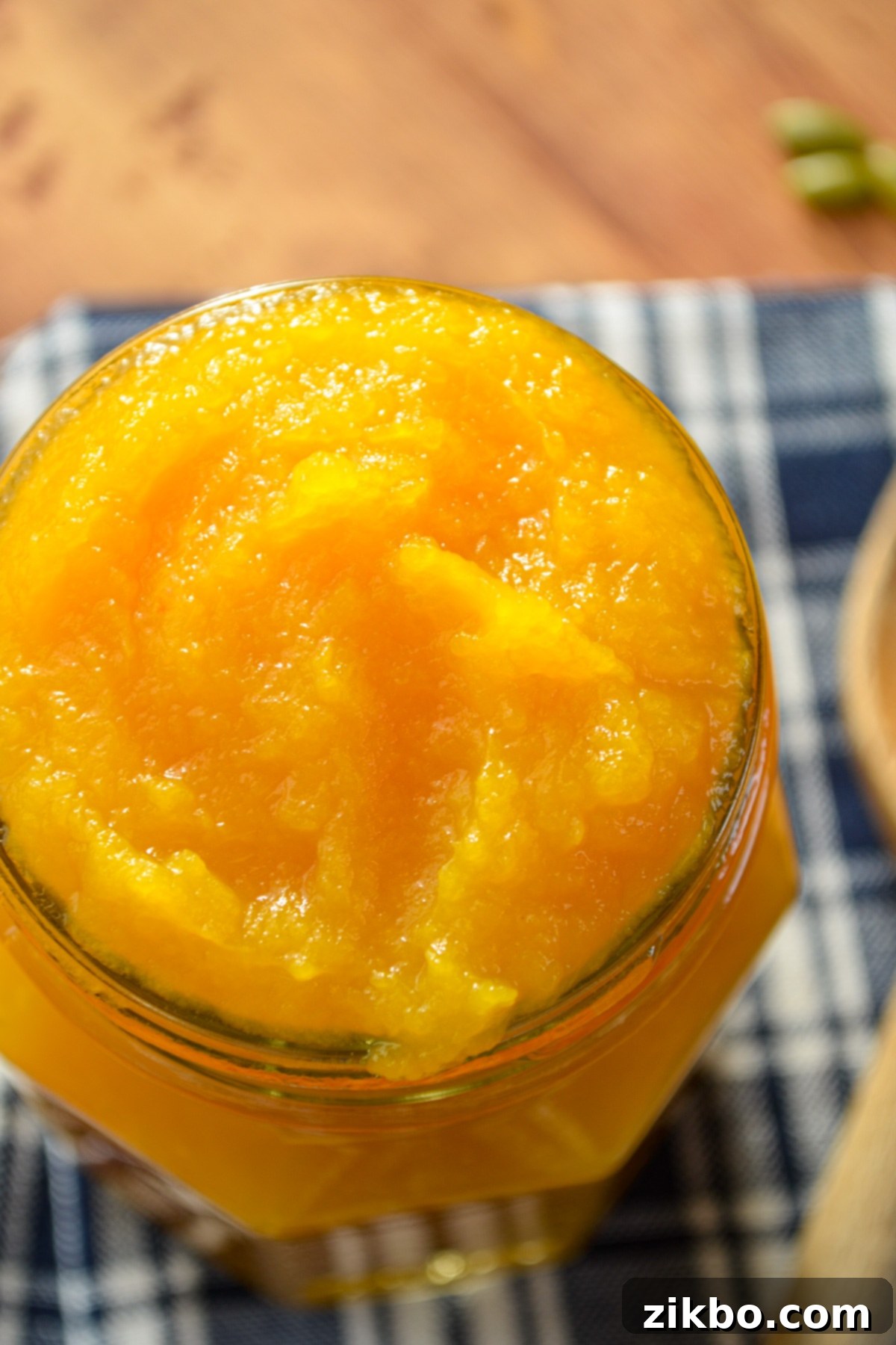 A jar of homemade pumpkin puree on a blue napkin.