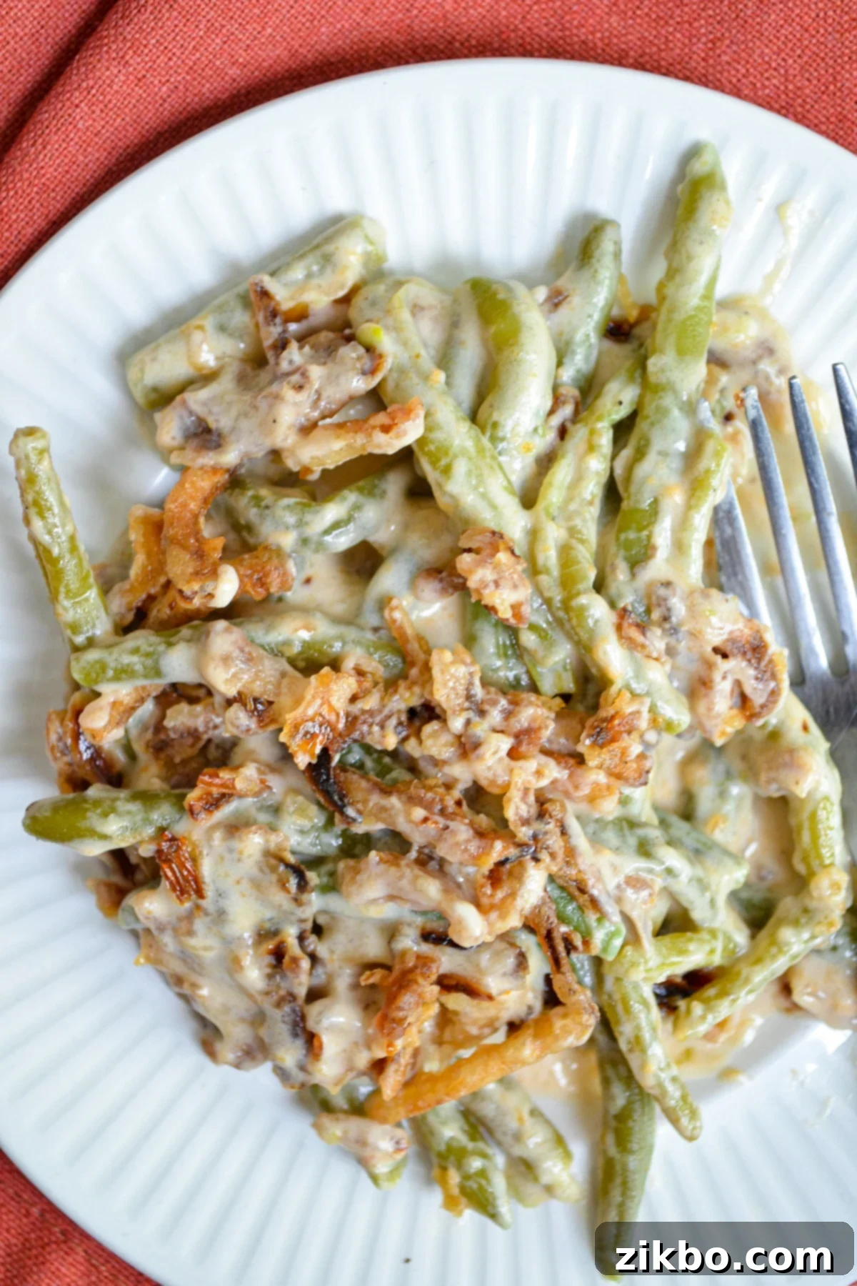 A plate of green bean casserole, topped with french fried onions.