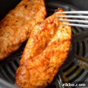 Chicken breasts covered in a rich blend of blackening seasonings, awaiting their transformation in the air fryer.