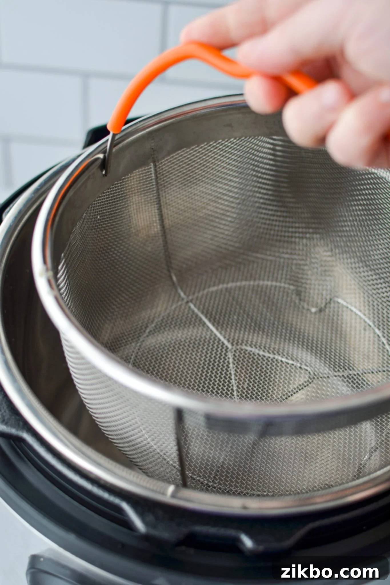 Lowering a steamer basket into the insert of an Instant Pot.