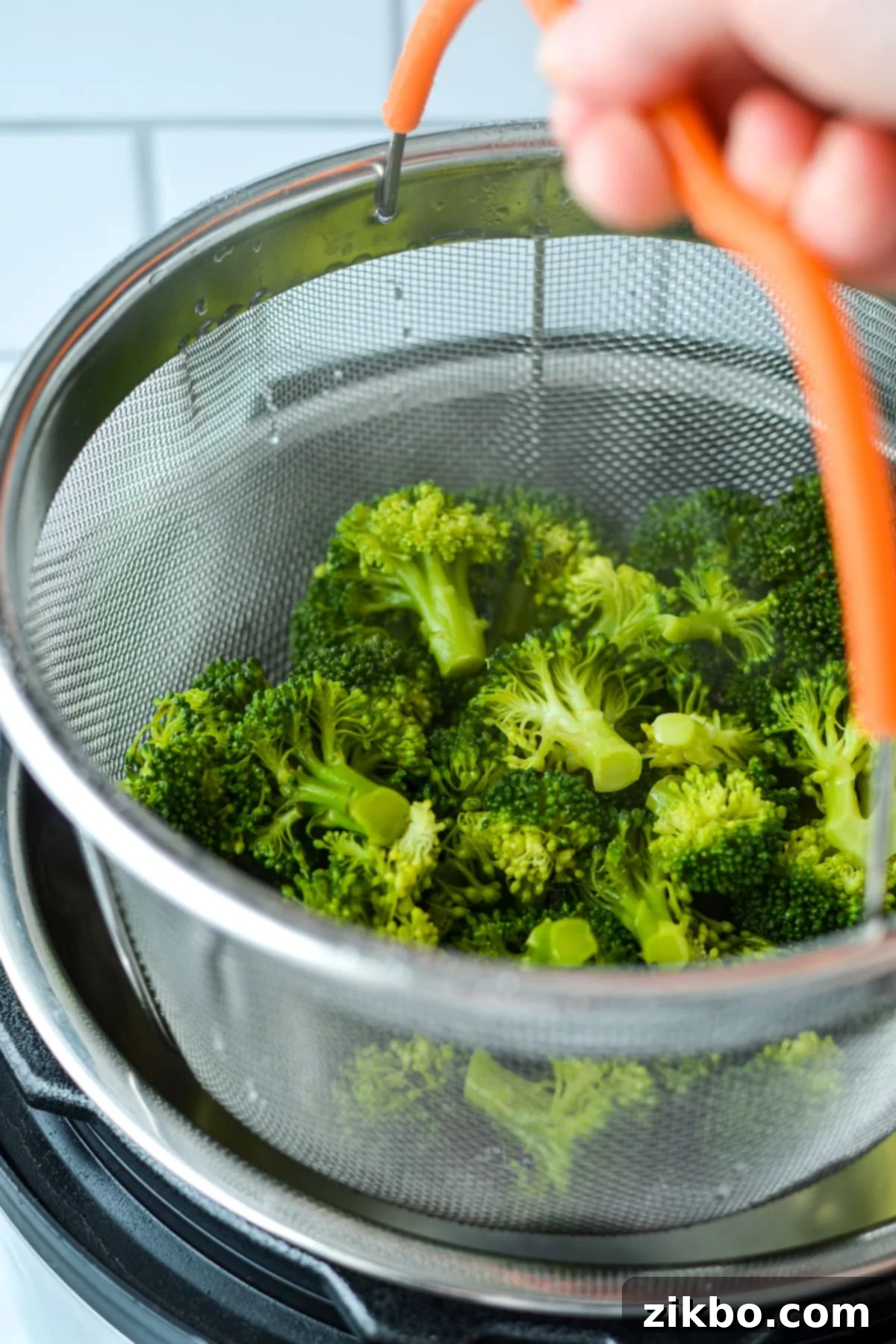 Removing a steamer basket from an Instant Pot after cooking.