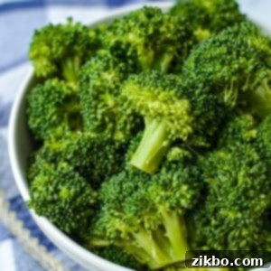 A bowl of broccoli that has been cooked.