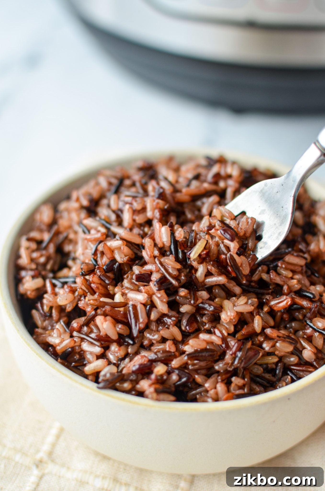 A close-up shot of a bowl of fluffy wild rice blend, with a fork gently taking a portion, highlighting its inviting texture.