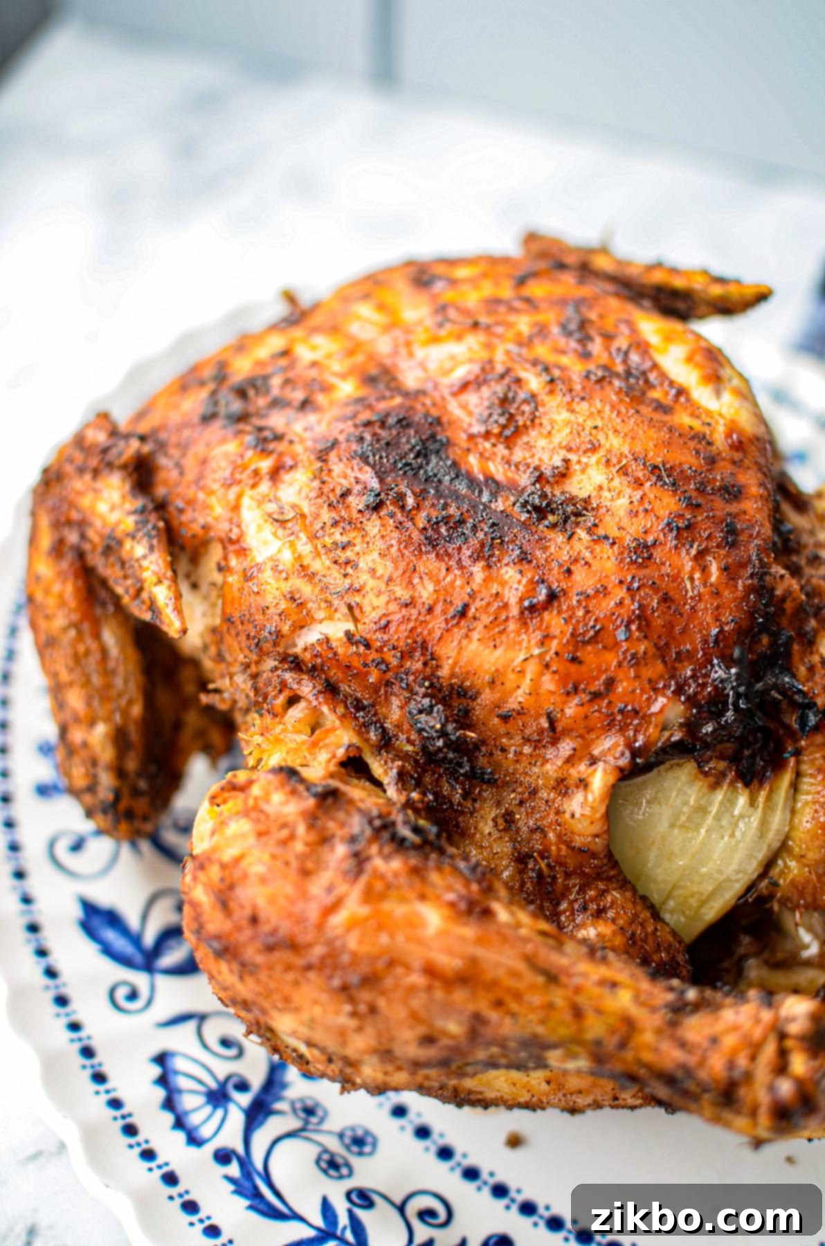 A perfectly roasted whole chicken with crispy golden-brown skin, fresh from the air fryer.