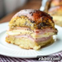 Golden Air Fryer Ham and Cheese Sliders 8 A perfectly baked ham and cheese slider on a plate, featuring melted cheese and a golden brown roll.