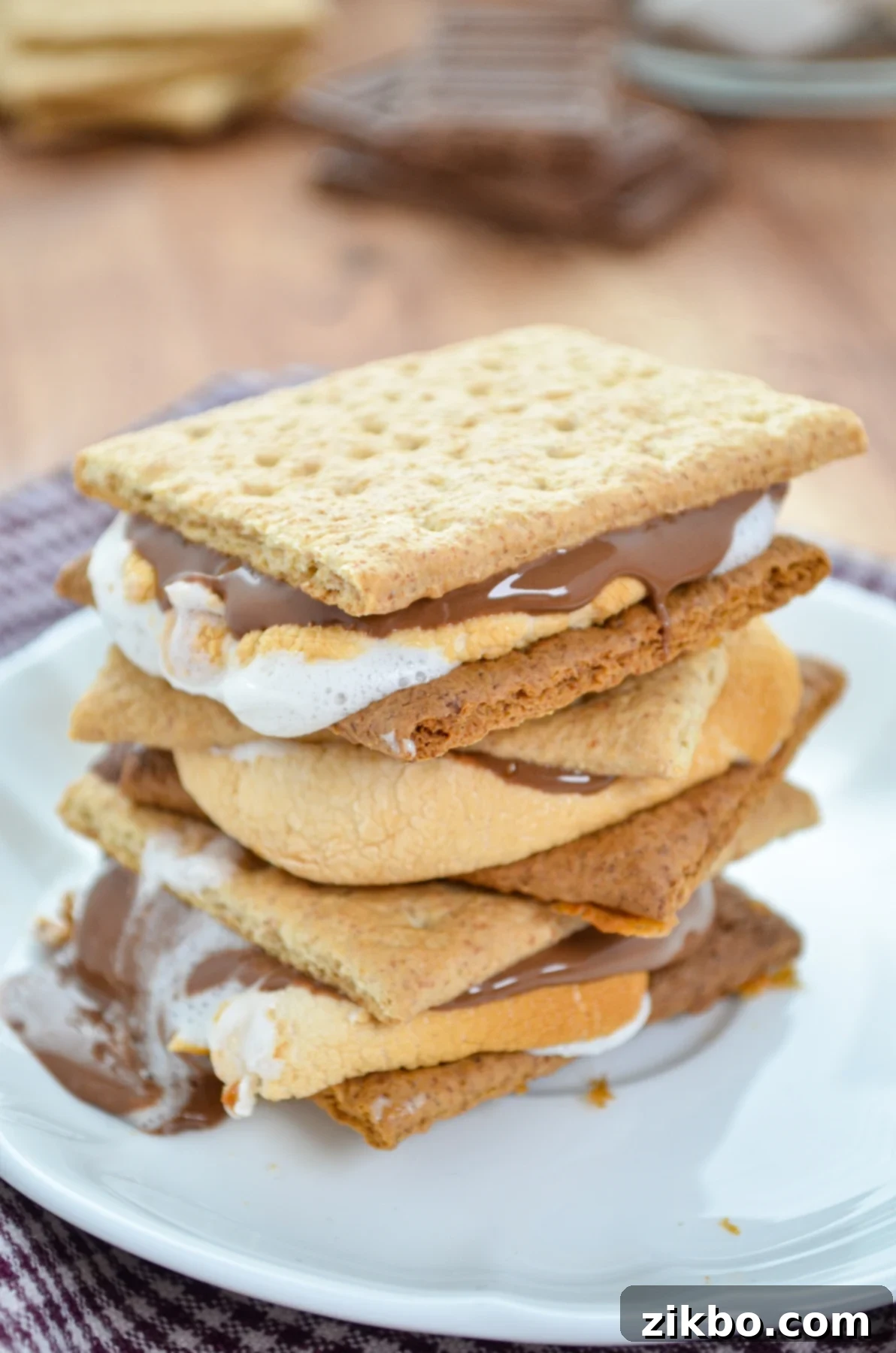 A stack of three s'mores on a white plate. 