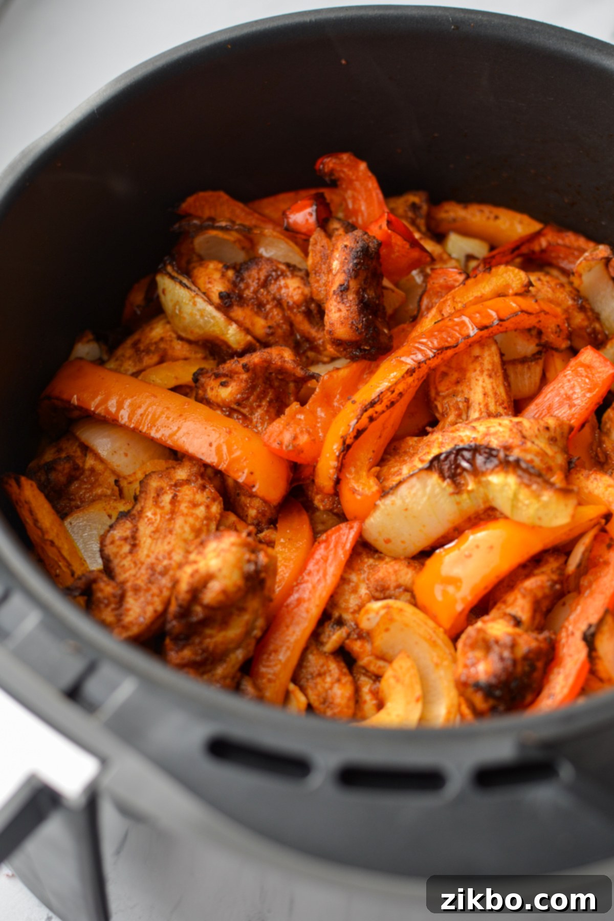 Crispy Air Fryer Chicken Fajitas 2 A vibrant plate of cooked air fryer chicken fajitas with colorful bell peppers and onions, ready to be served.
