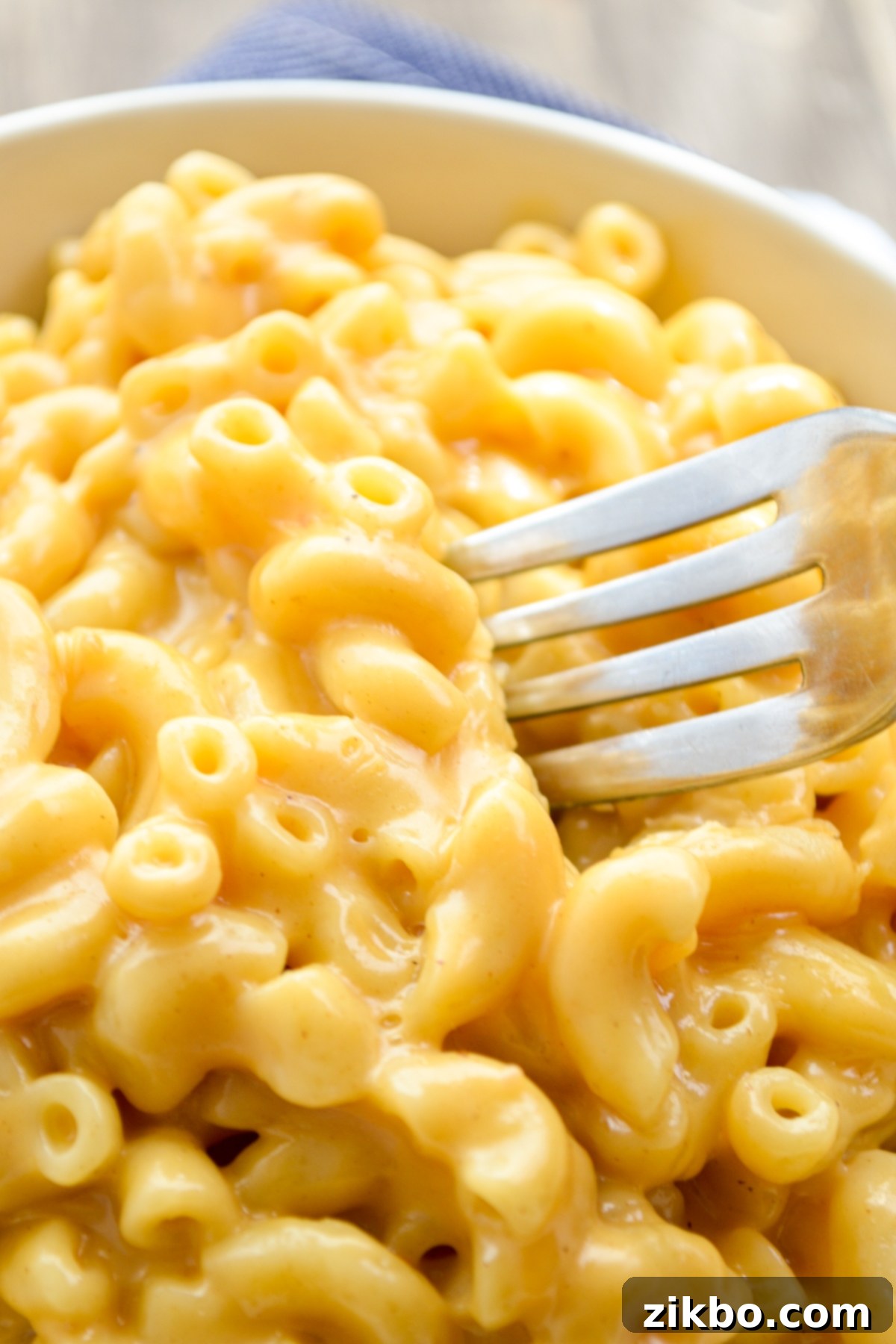 Quick and Creamy 5-Ingredient Instant Pot Velveeta Mac and Cheese 2 A fork sunken into a big bowl of Instant Pot Mac and Cheese, showing creamy texture.