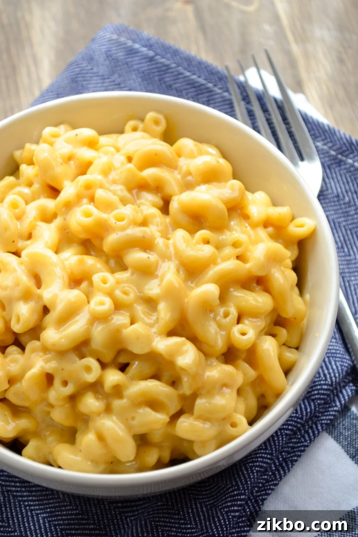 Quick and Creamy 5-Ingredient Instant Pot Velveeta Mac and Cheese 3 A close-up of a bowl of Mac and Cheese on a blue napkin, highlighting its cheesy texture.