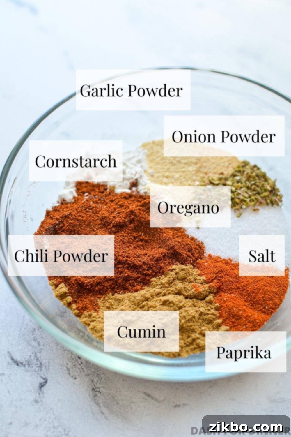 A beautifully arranged bowl of individual spices, labeled, that will be blended to create the homemade taco seasoning.