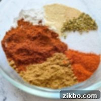 A small bowl filled with various seasonings that come together to make taco seasoning.