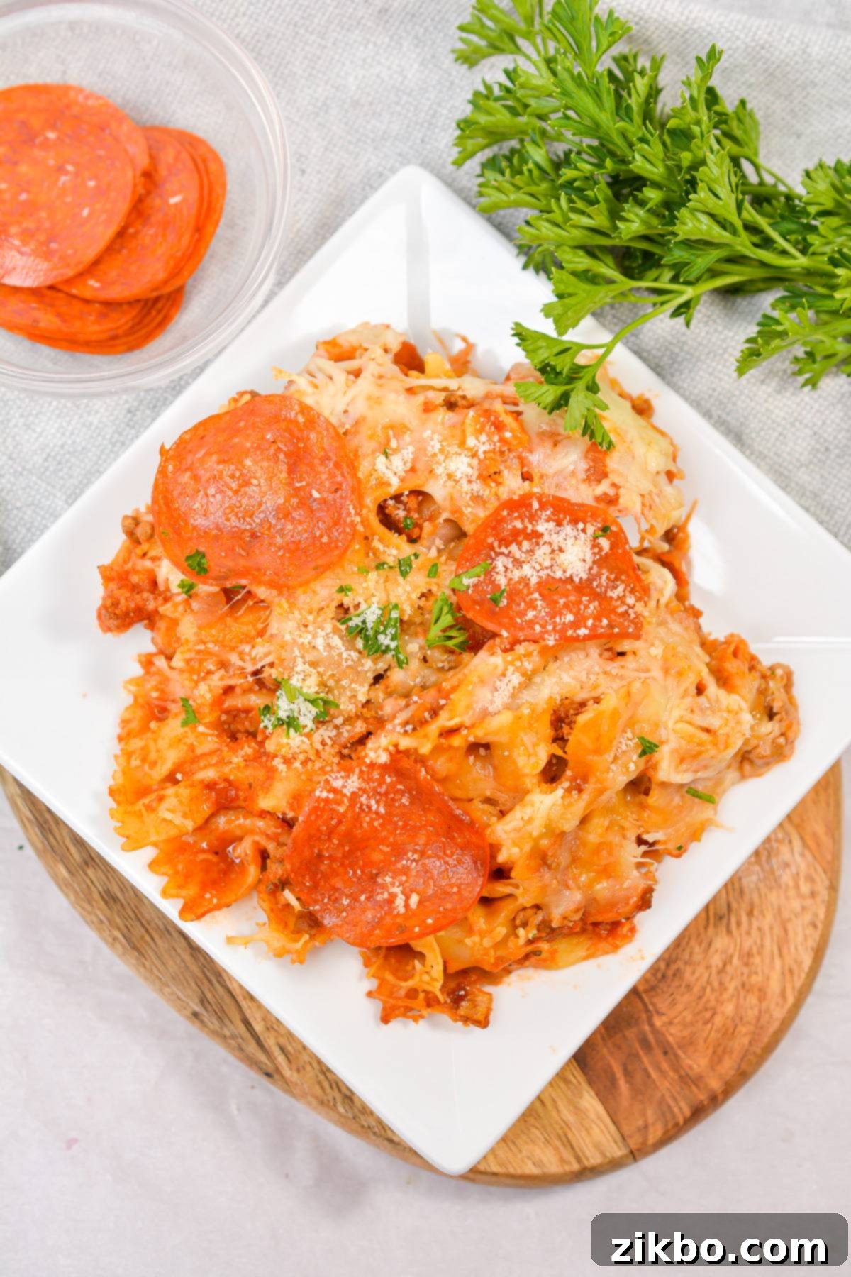 Slow Cooker Pizza Delight 7 An overhead shot of a plate of pizza casserole, generously topped with crispy pepperoni and melted mozzarella cheese.