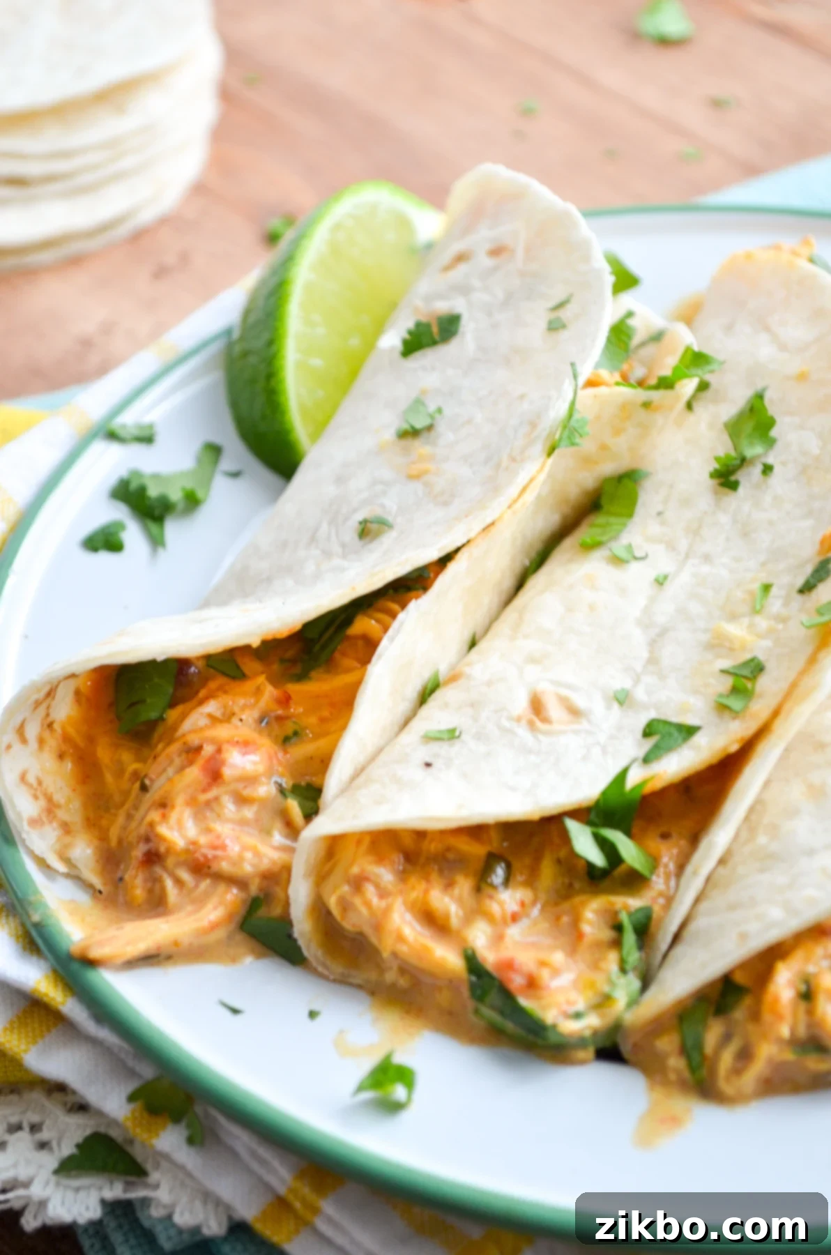Queso Chicken Tacos, garnished with lime and cilantro.