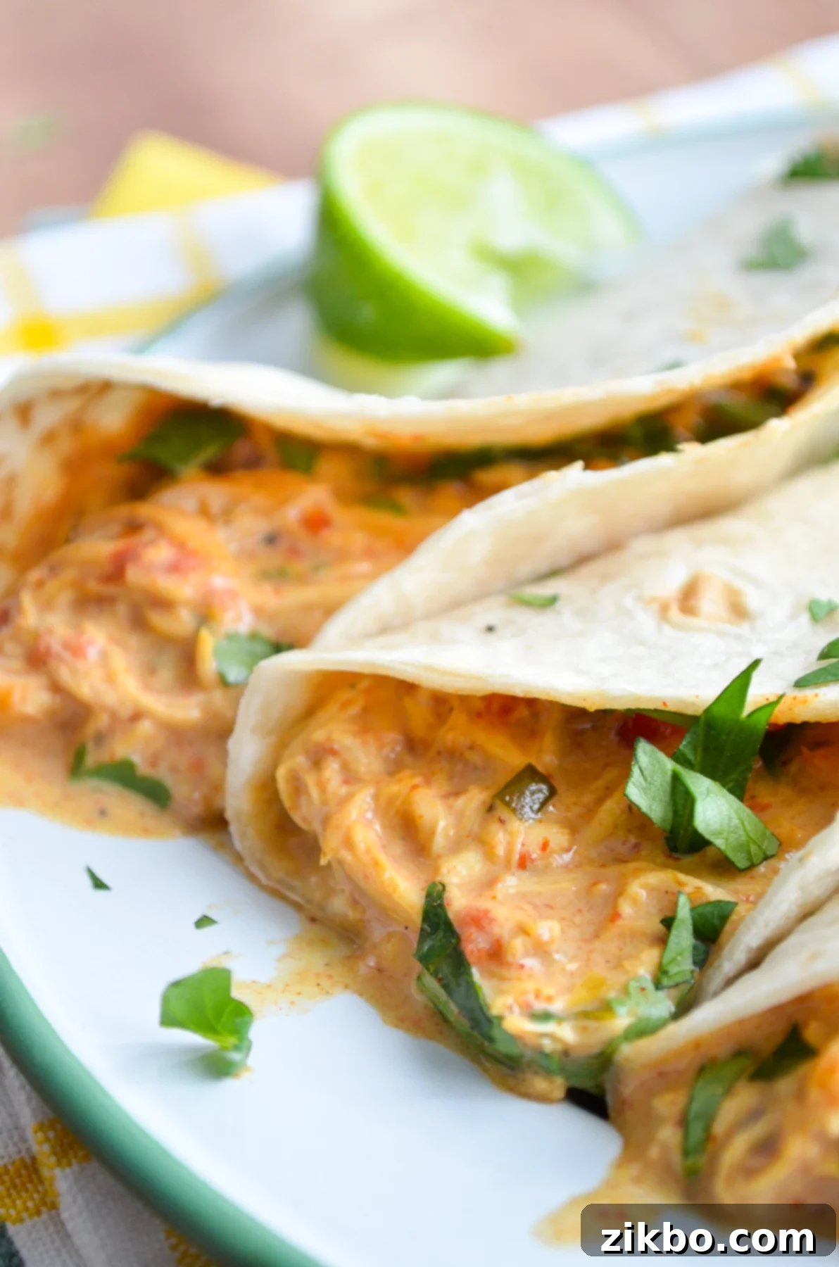 Queso Chicken Tacos, garnished with lime and cilantro.