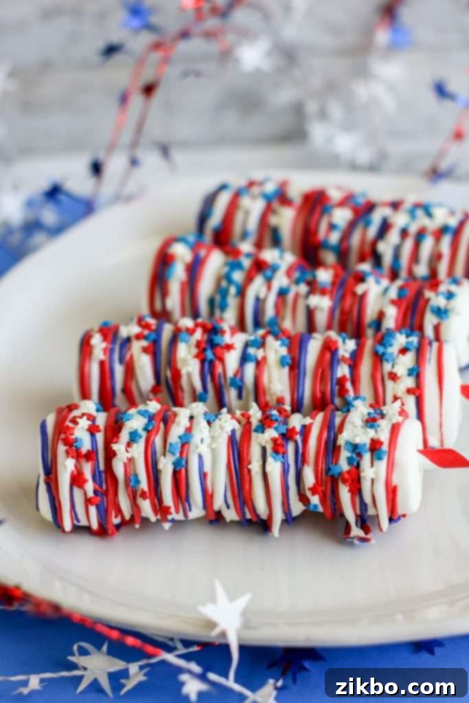 Patriotic Marshmallow Pops, perfect for kids, decorated with red, white, and blue, served on sticks for easy handling during fireworks.