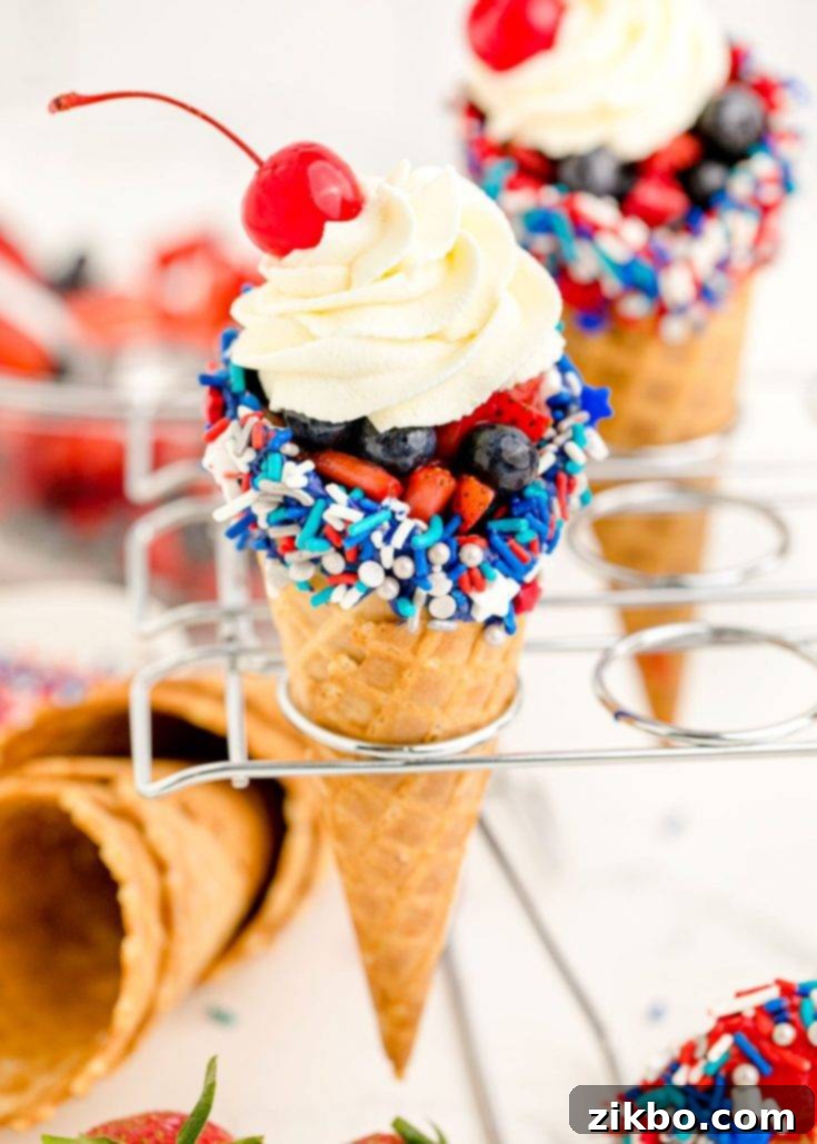 Cheesecake Stuffed Waffle Cones for 4th of July, filled with no-bake cheesecake and adorned with patriotic toppings like berries and sprinkles.