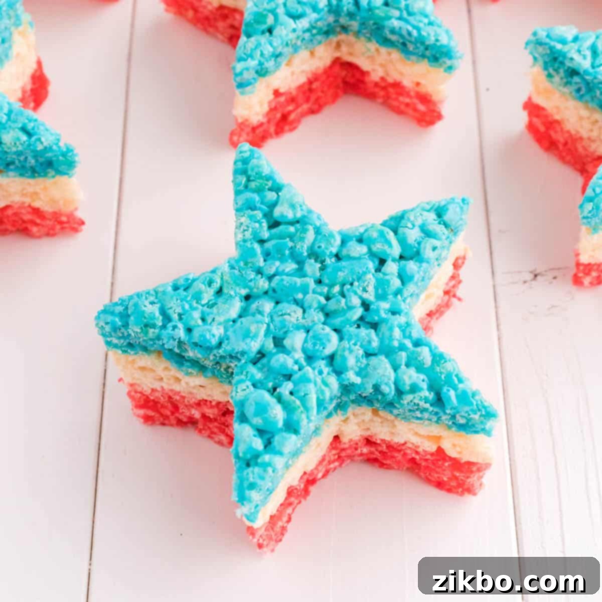 4th of July Rice Krispie Treats, layered in red, white, and blue, and cut into festive star shapes, a popular patriotic dessert.