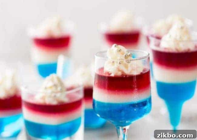 Individual Patriotic 4th of July Layered Jello cups, featuring vibrant red, white, and blue layers for a fun party dessert.