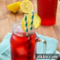 A glass of Passion Tea Lemonade, garnished with lemon wedges, from the Starbucks Copycat Recipe.