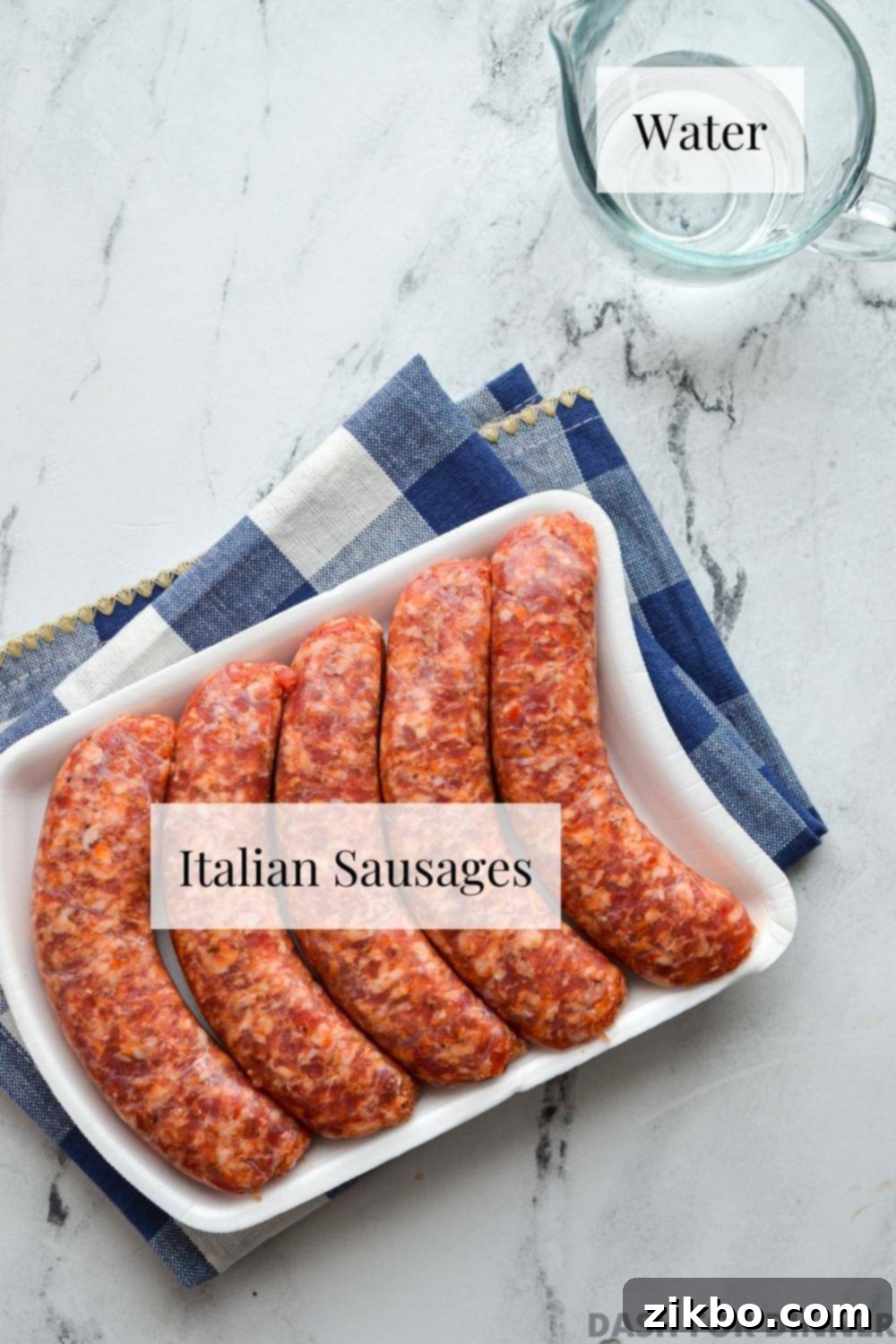 A package of Italian sausages and a small glass cup of water.