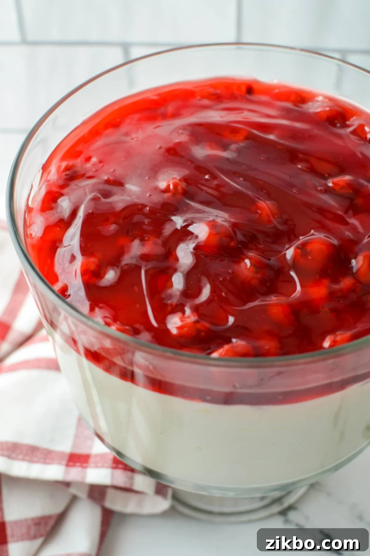 A beautiful trifle dish brimming with luscious lazy cheesecake salad, layered with creamy cheesecake base and vibrant cherry pie filling.