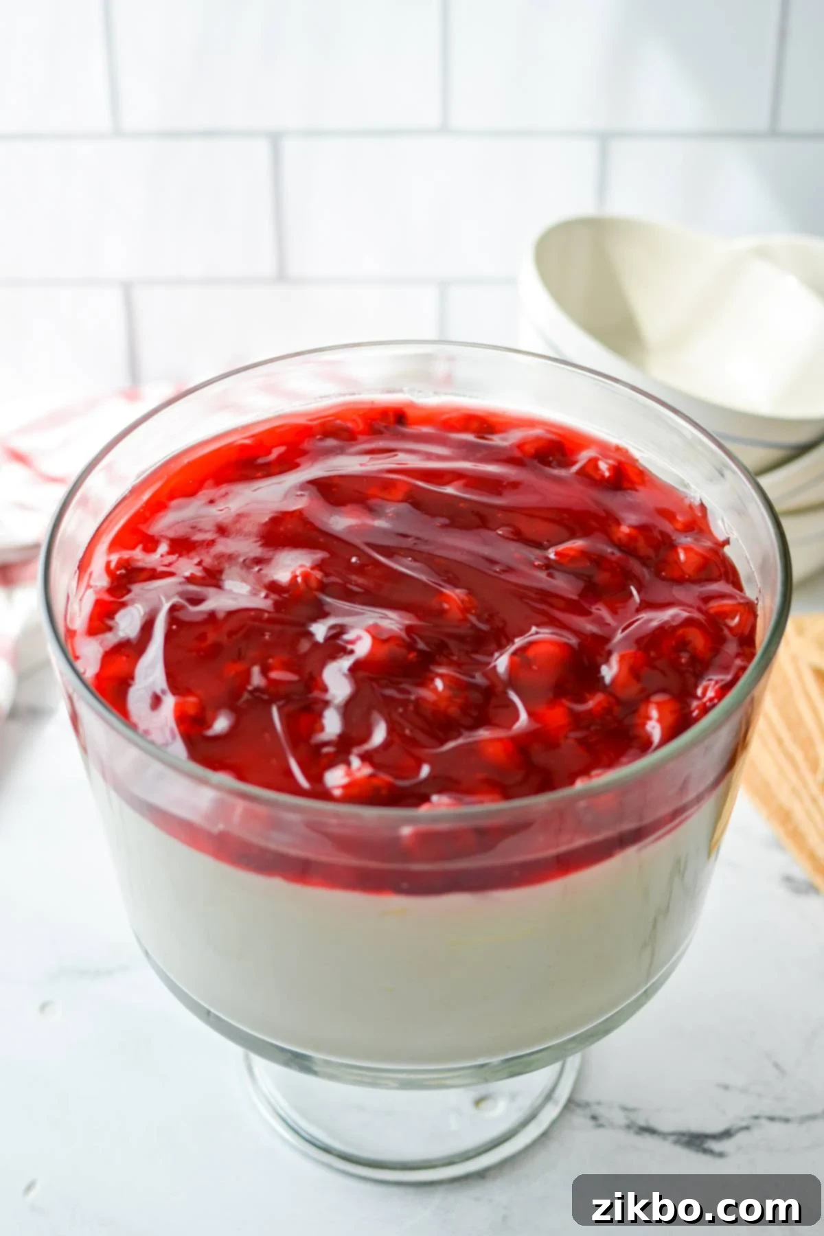 A stunning trifle dish completely filled with decadent cheesecake salad, ready to be enjoyed.