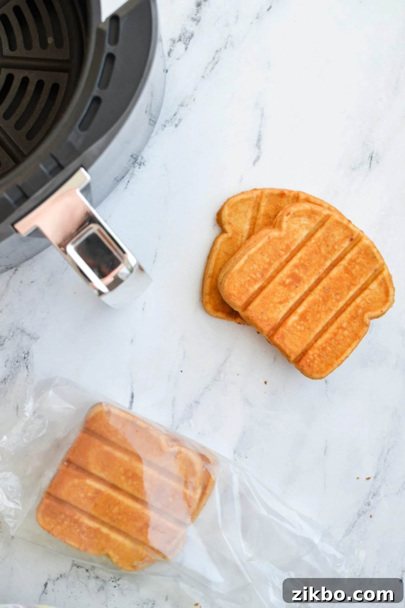 A bag of frozen French toast sticks next to an open air fryer basket, ready for cooking.