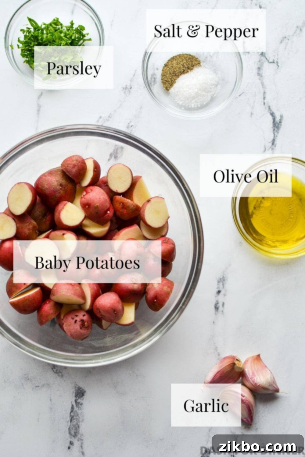 The simple ingredients needed to make air fryer baby potatoes, including olive oil, salt, pepper, garlic powder, and fresh parsley, neatly arranged.