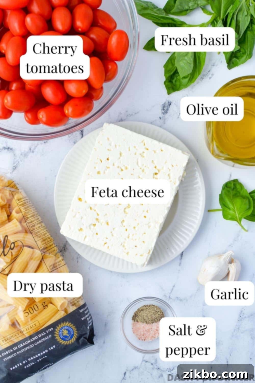 The ingredients needed to make baked feta: feta, tomatoes, basil, olive oil, and pasta.