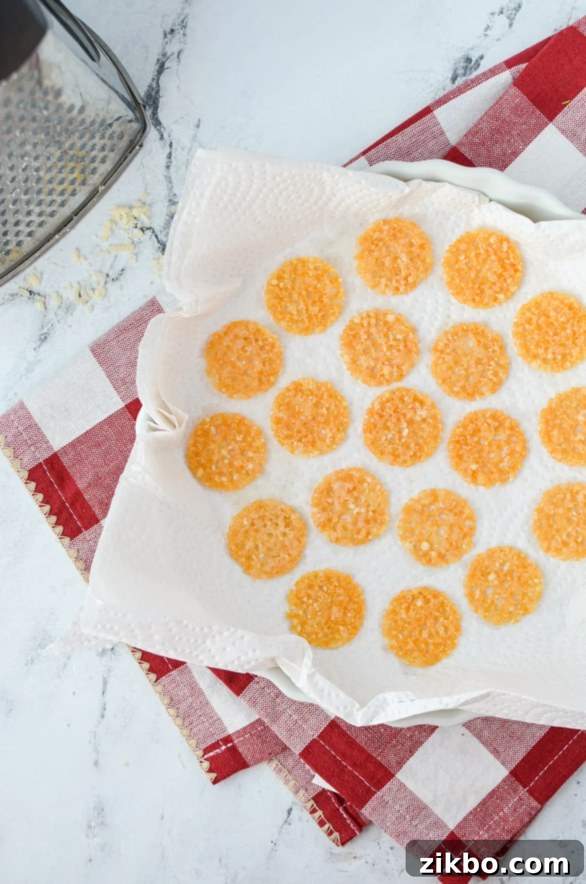 Savory Parmesan Snaps 5 Adding parmesan crisps to a paper towel lined plate.