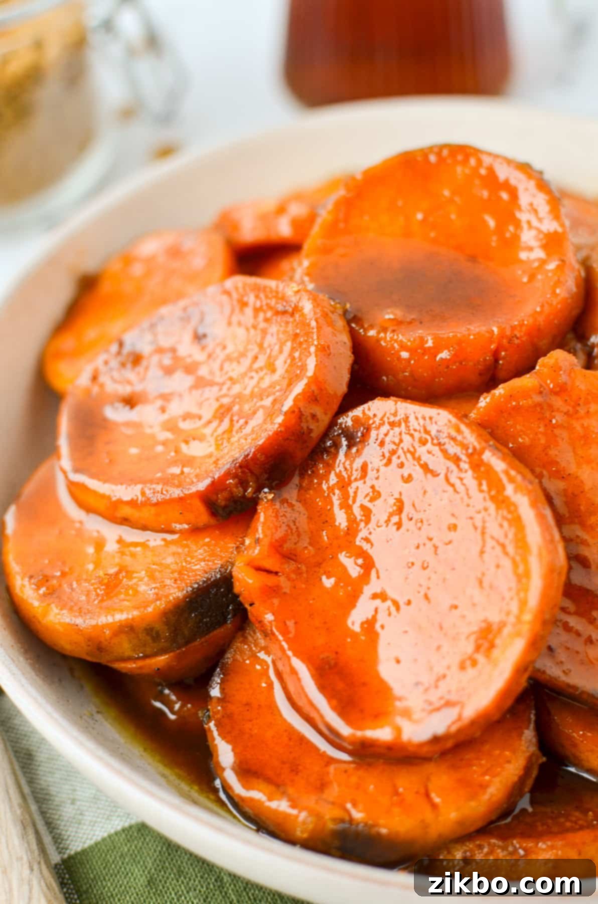 A bowl with sweet potato slices that have been covered in a glaze.