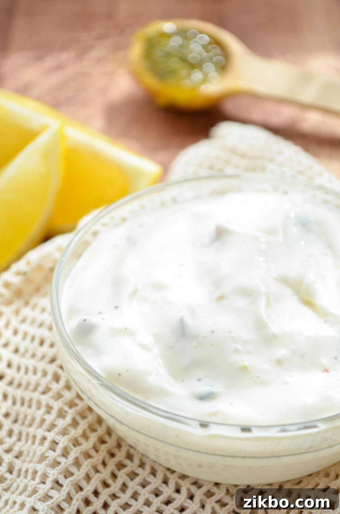 A small bowl of tartar sauce, some lemon wedges in the top corner.