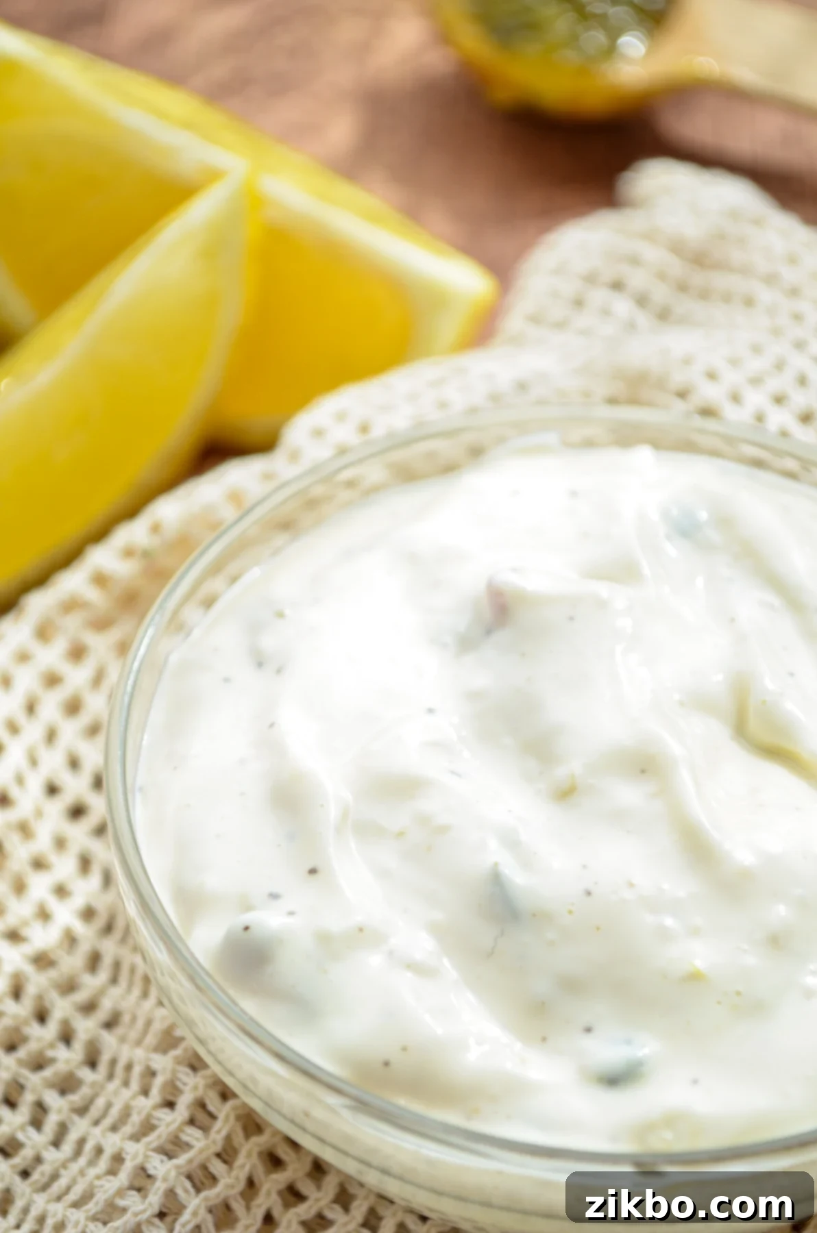A small bowl of tartar sauce, some lemon wedges in the top corner.