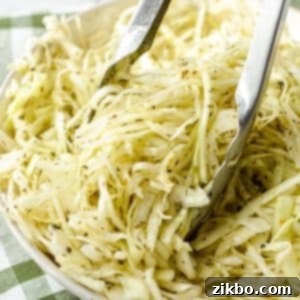 Tongs taking a portion of coleslaw.