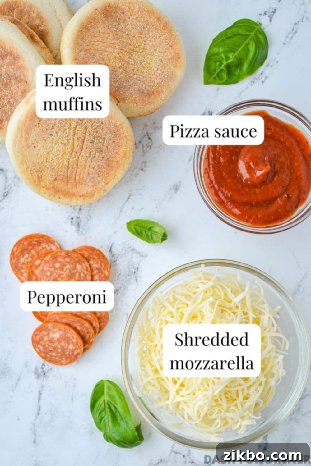 Easy English Muffin Pizzas 3 The ingredients needed to make English muffin pizzas, including sauce, pepperoni, and cheese.