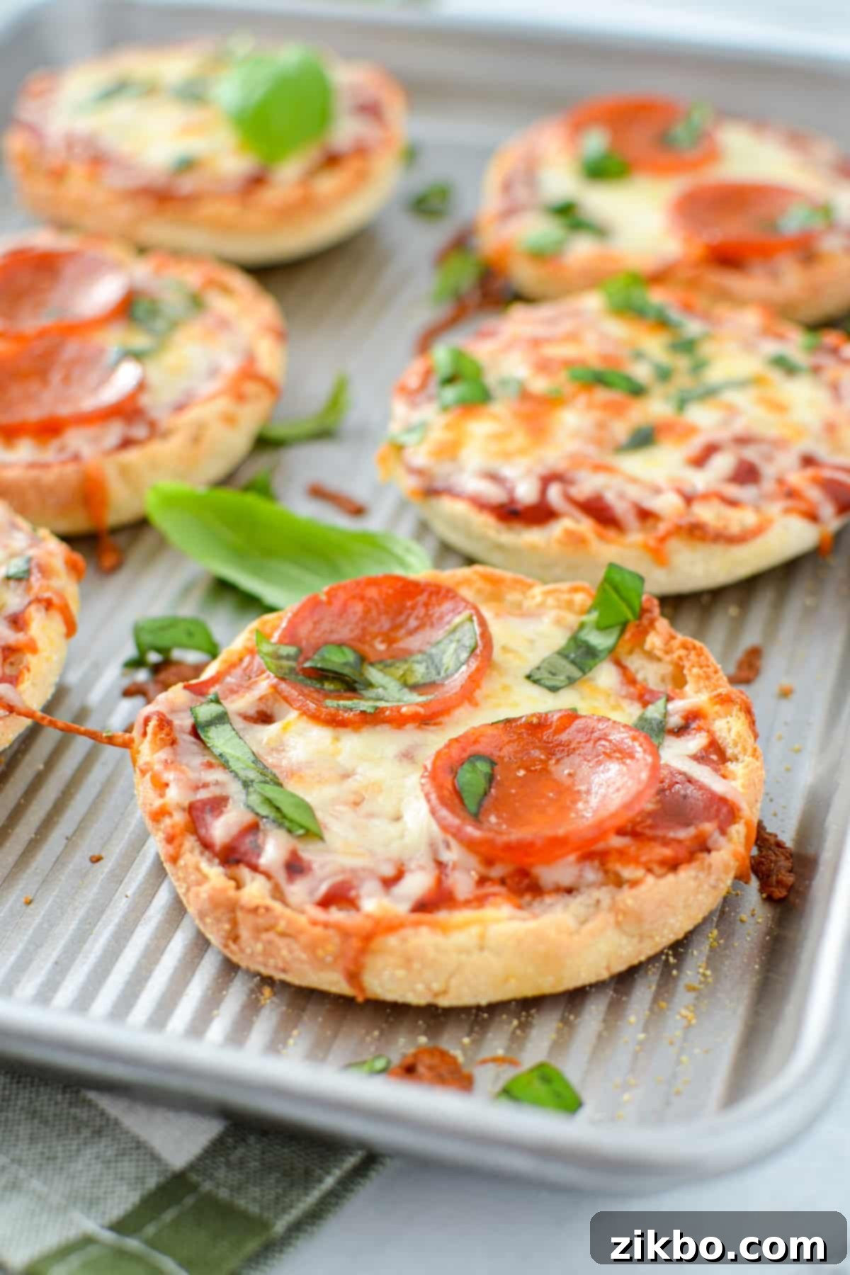 Easy English Muffin Pizzas 8 A baking sheet with baked mini pizzas on them.