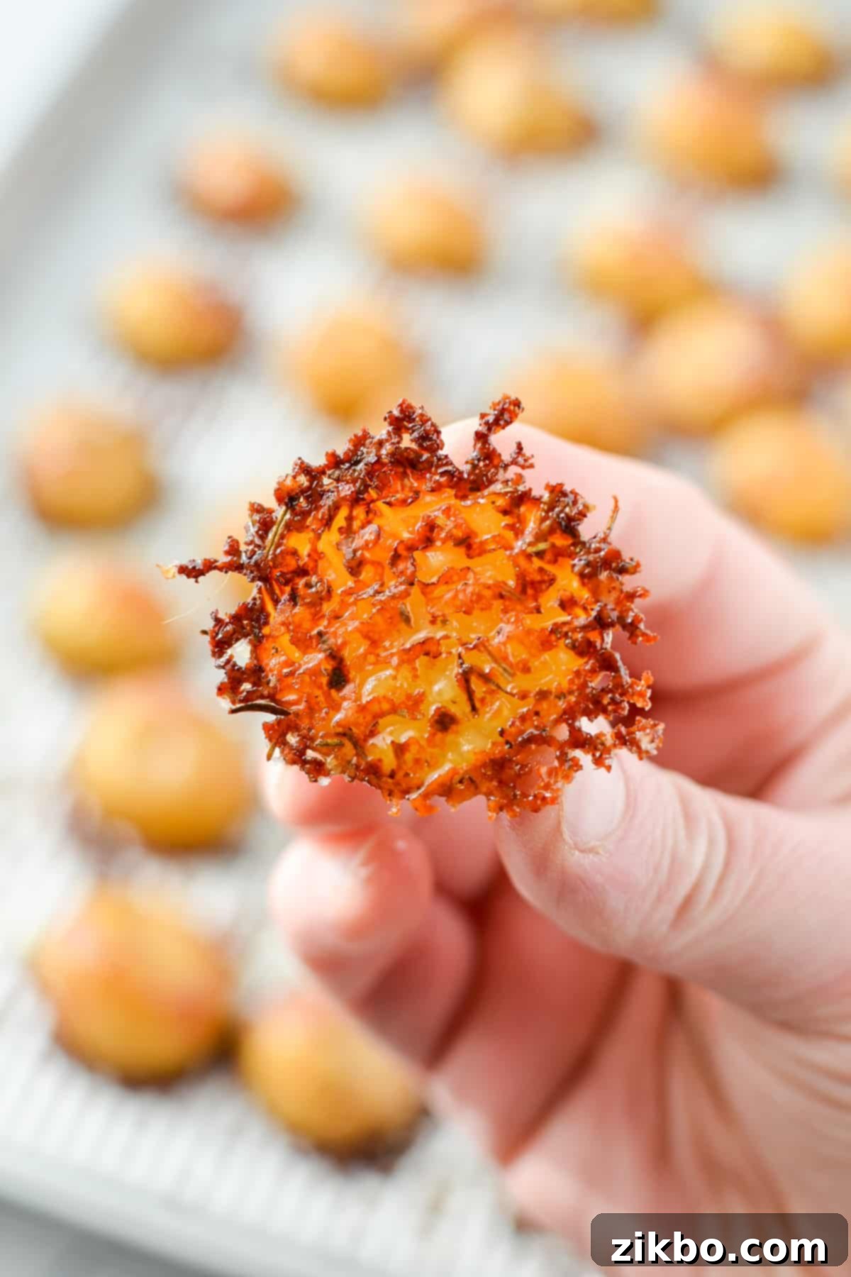 Crispy Parmesan Potatoes 2 A halved baby potato encrusted with parmesan cheese, showcasing the crispy crust.