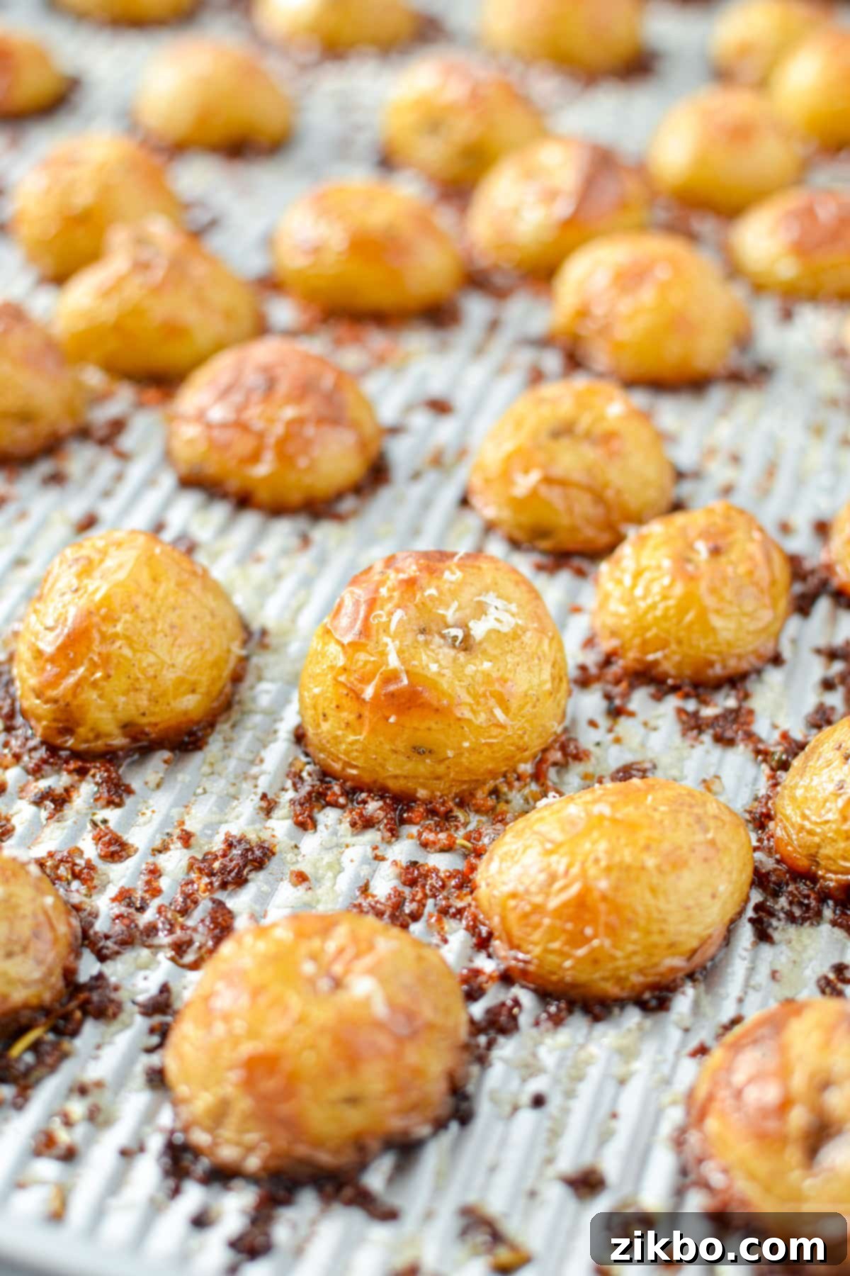 Crispy Parmesan Potatoes 7 A baking sheet with golden-brown, crispy potatoes crusted in parmesan cheese, fresh from the oven.