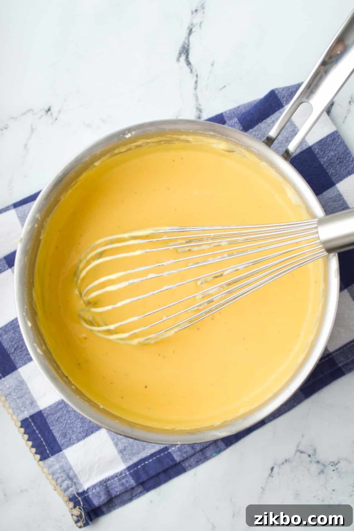 A saucepan filled with cheese sauce.