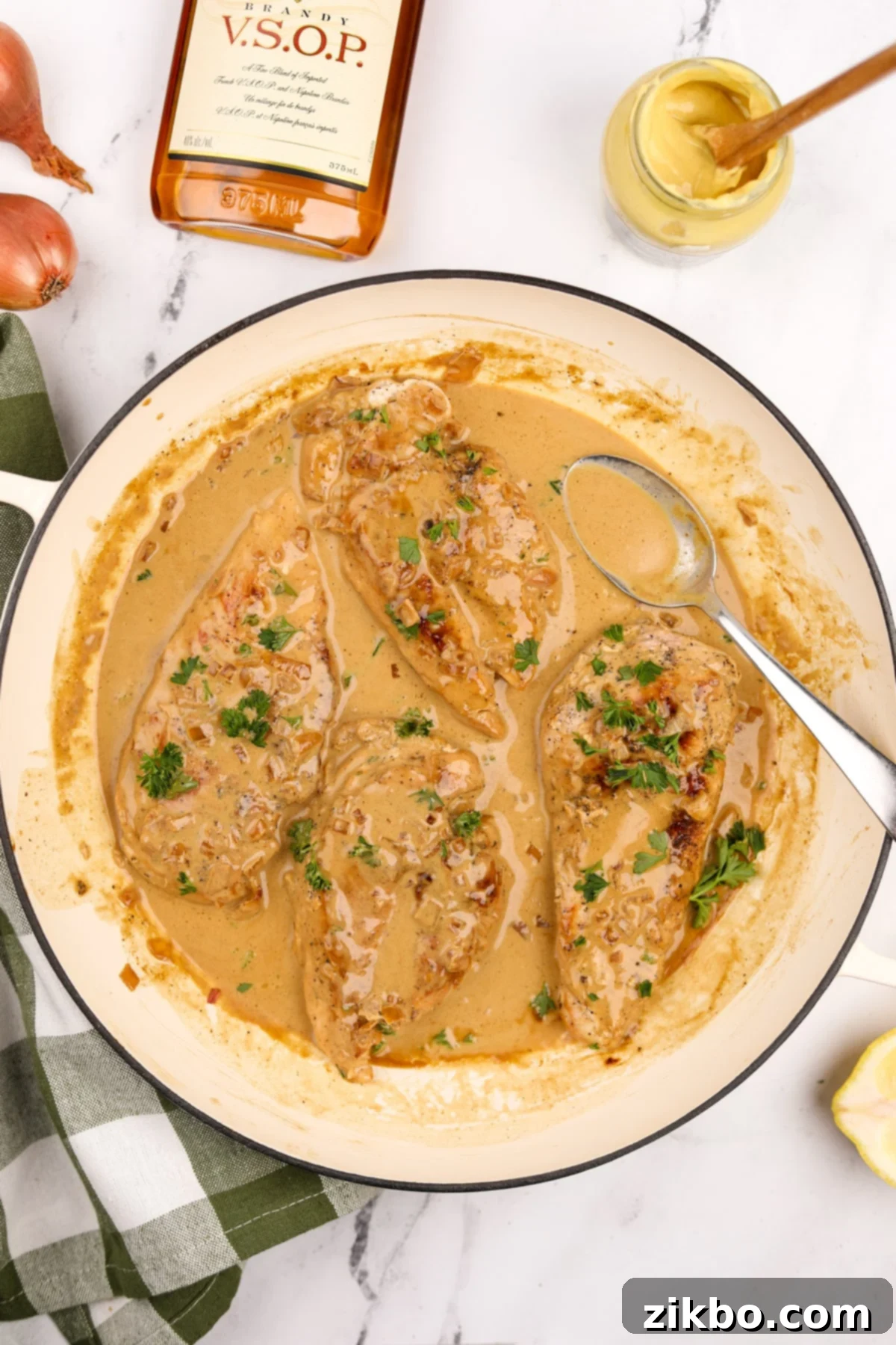 A skillet brimming with perfectly cooked chicken breasts, generously coated in a rich, creamy Diane sauce, garnished with fresh parsley.