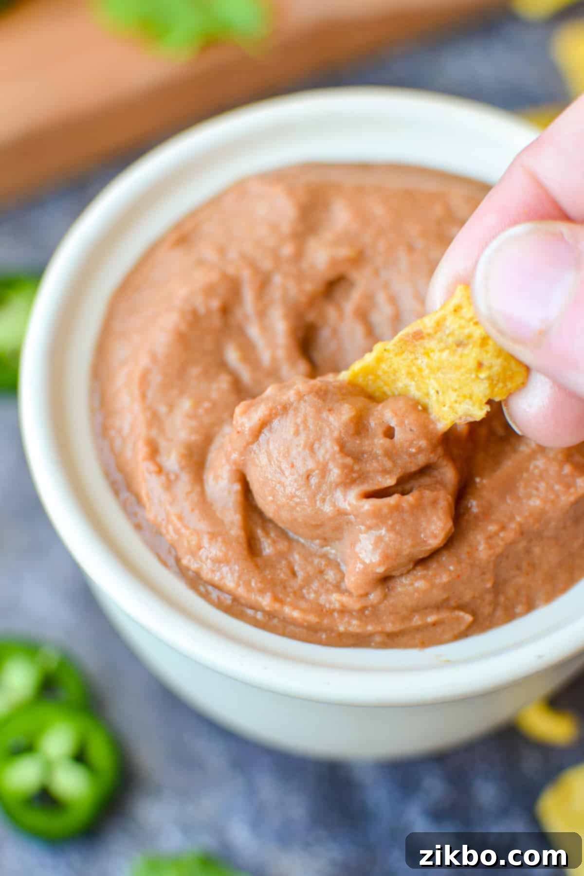 Ultimate Homemade Fritos Bean Dip 8 A close-up of creamy, smooth bean dip in a ceramic bowl, ready to be scooped.