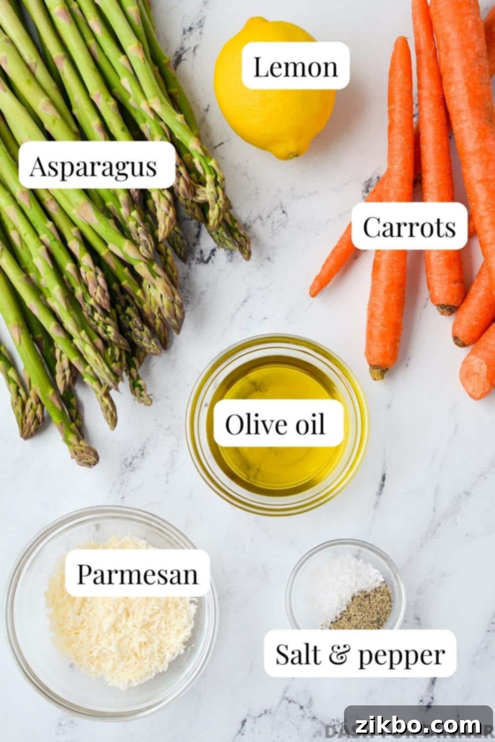 The ingredients needed to make roasted asparagus and carrots: fresh carrots, high-quality olive oil, seasoning blend, a vibrant lemon, Parmesan cheese, and fresh asparagus spears.