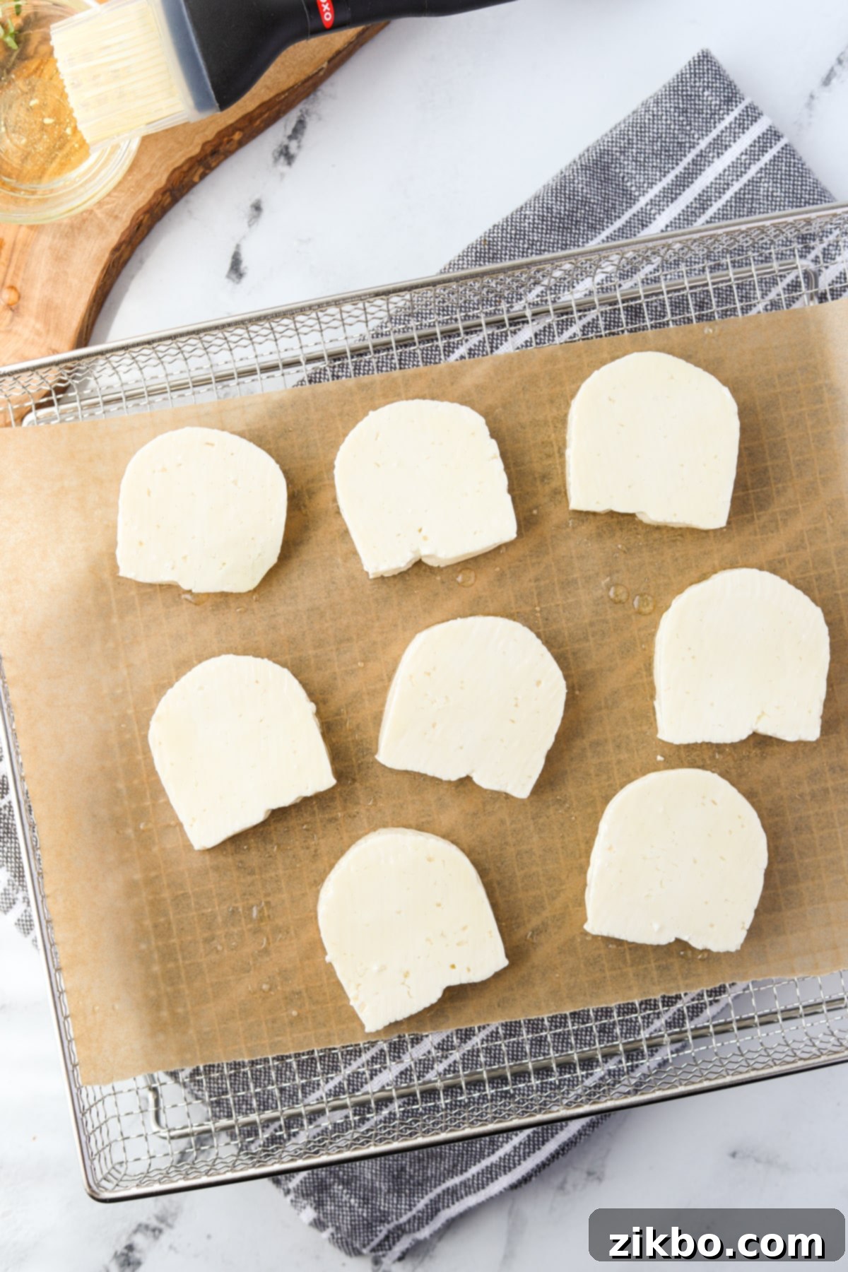 An air fryer tray with halloumi cheese slices arranged in a single layer.